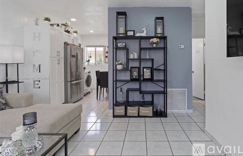A modern living room with a glass table and a black bookshelf.