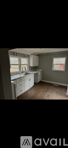 A kitchen with white cabinets and a window.