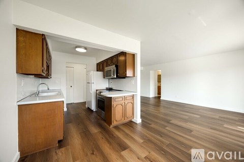 A kitchen with wooden cabinets and a white fridge.