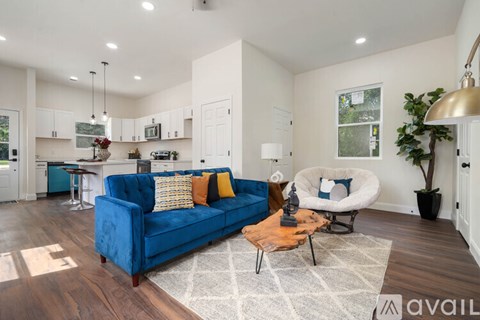A blue couch with pillows is in the middle of a living room.