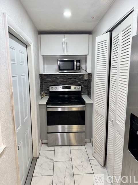 A kitchen with a stove top oven and a microwave above it.