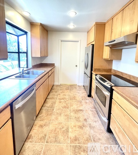 A kitchen with wooden cabinets and tile flooring.