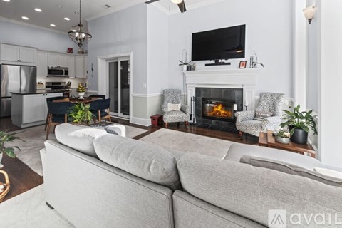 A living room with a grey couch and a fireplace.
