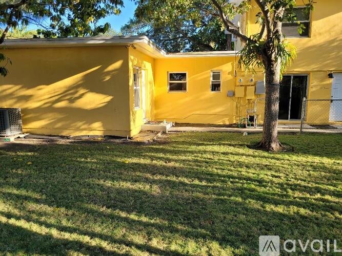 A yellow house with a tree in front of it.