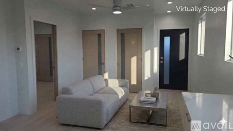 A modern living room with a grey sofa and a glass coffee table.