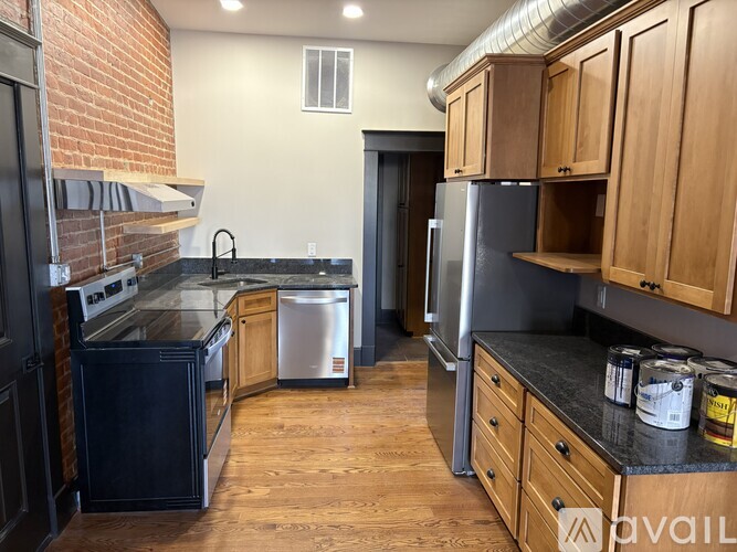 A kitchen with a black countertop and wooden cabinets.