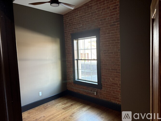 A room with a brick wall and a window.
