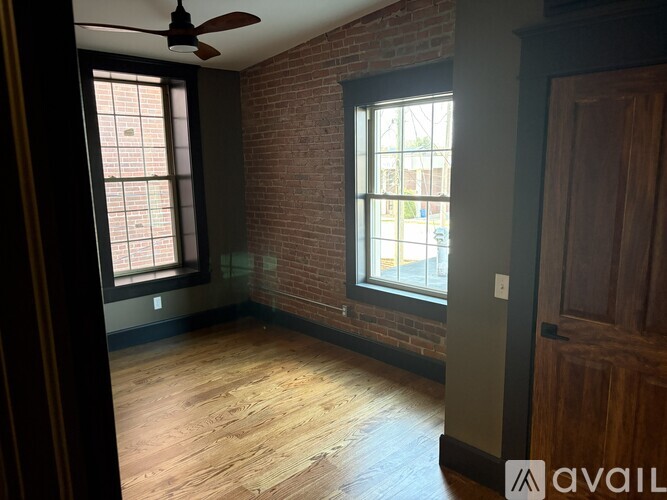 A room with a brick wall and a ceiling fan.