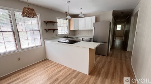 A kitchen with wooden floors and white walls.