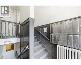 A staircase with a metal railing and a sign that says "Access to units 1 & 2.".