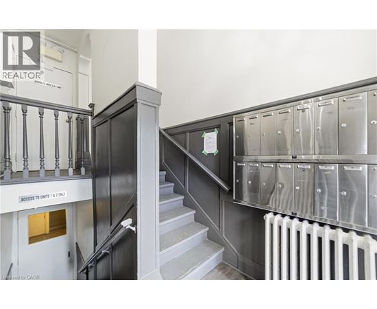 A staircase with a metal railing and a sign that says "Access to units 1 & 2.".