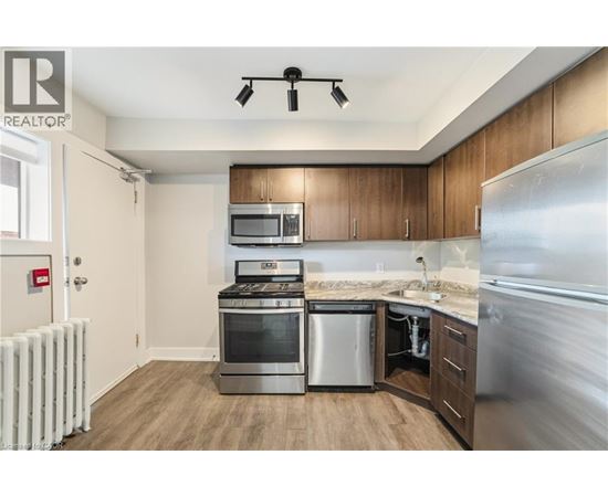 A modern kitchen with wooden cabinets and stainless steel appliances.