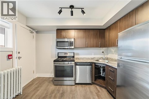 A modern kitchen with wooden cabinets and stainless steel appliances.