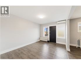 A room with a wooden floor and a black door.