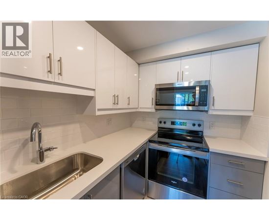 A modern kitchen with white cabinets and stainless steel appliances.