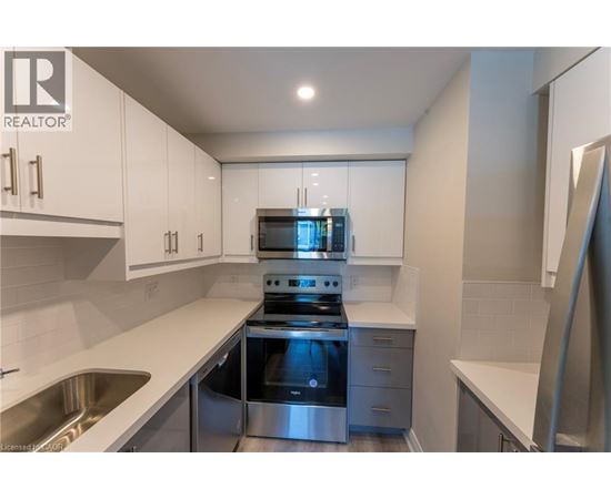 A modern kitchen with stainless steel appliances and white cabinets.