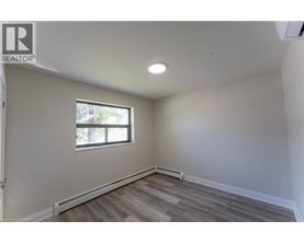 A room with a window and wooden flooring.