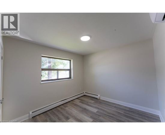 A room with a window and wooden flooring.
