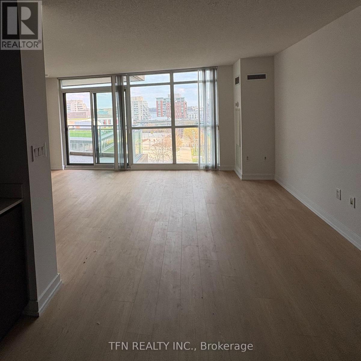 A large empty room with a view of the city through the windows.