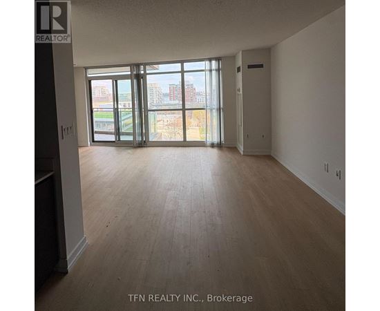 A large empty room with a view of the city through the windows.