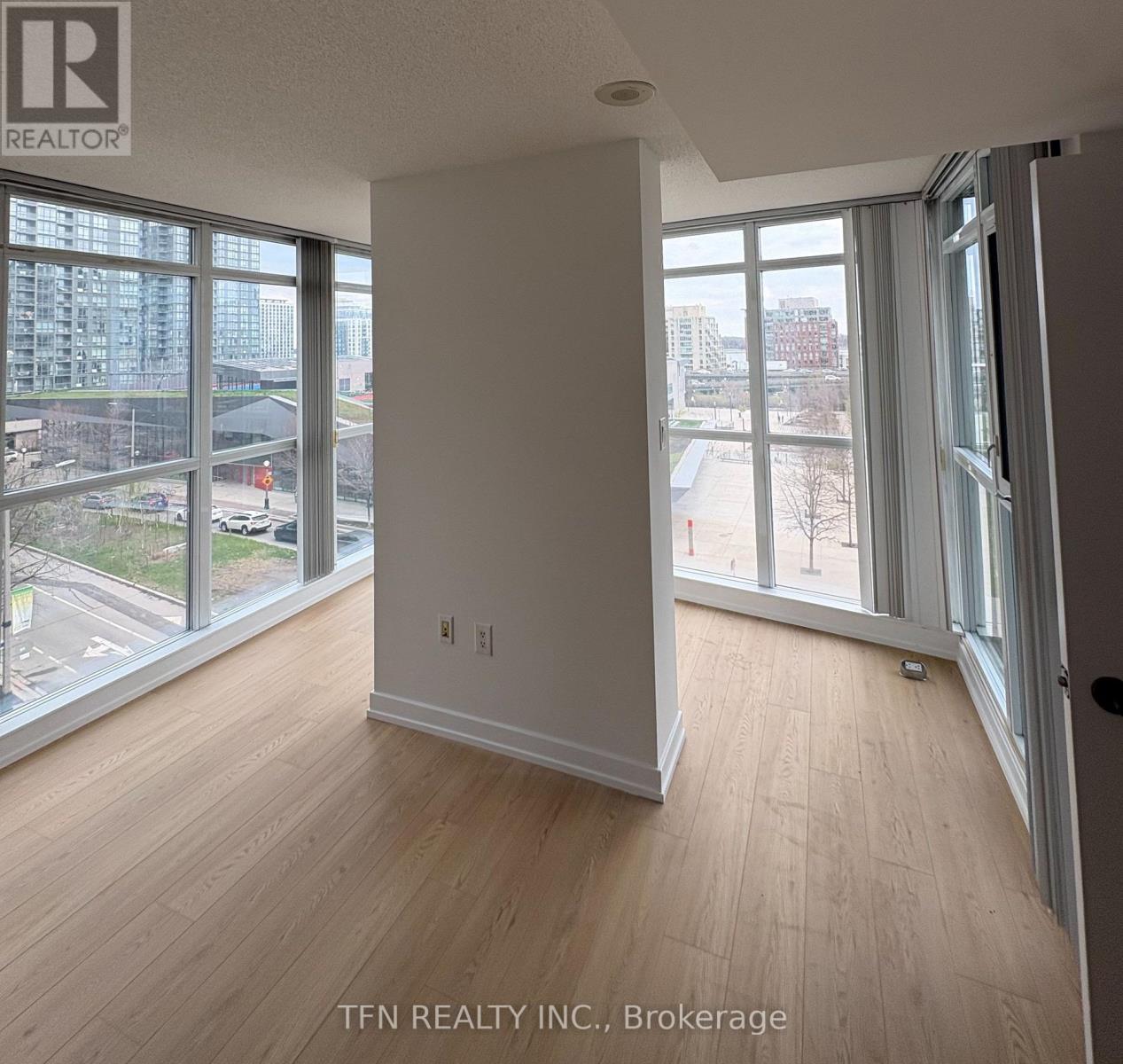 A room with a view of the city through large windows.