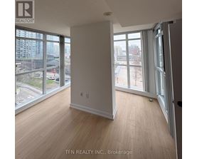 A room with a view of the city through large windows.