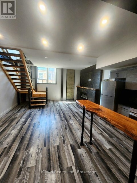A room with wooden floors and a staircase.