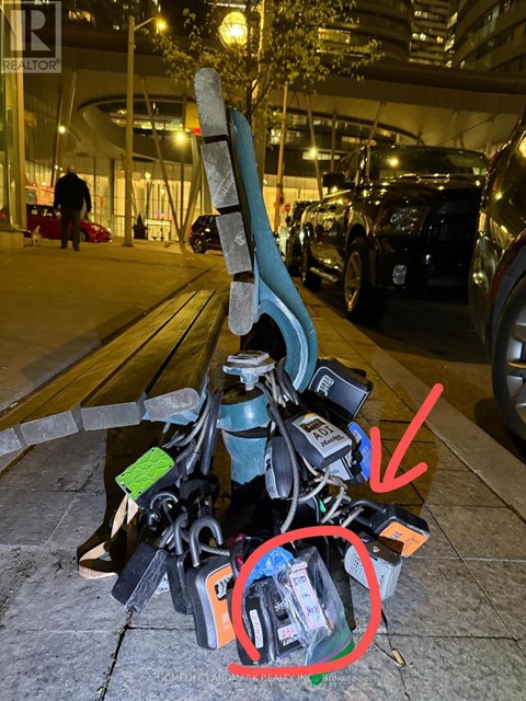 A pile of electronic junk with a skateboard leaning on it.