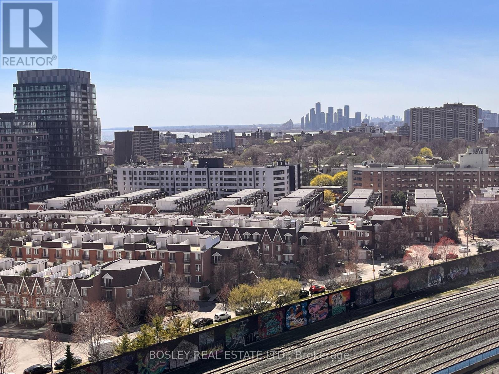 A cityscape with a mix of residential and commercial buildings, with a clear blue sky above.