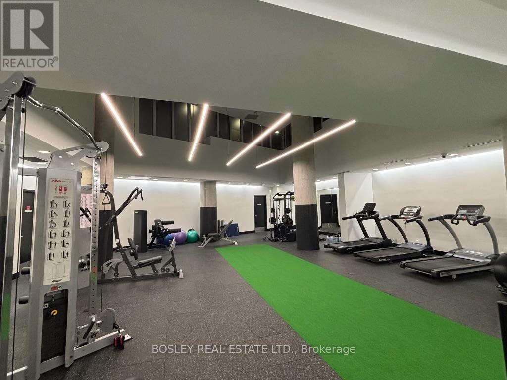 A gym with a green mat and a variety of equipment.