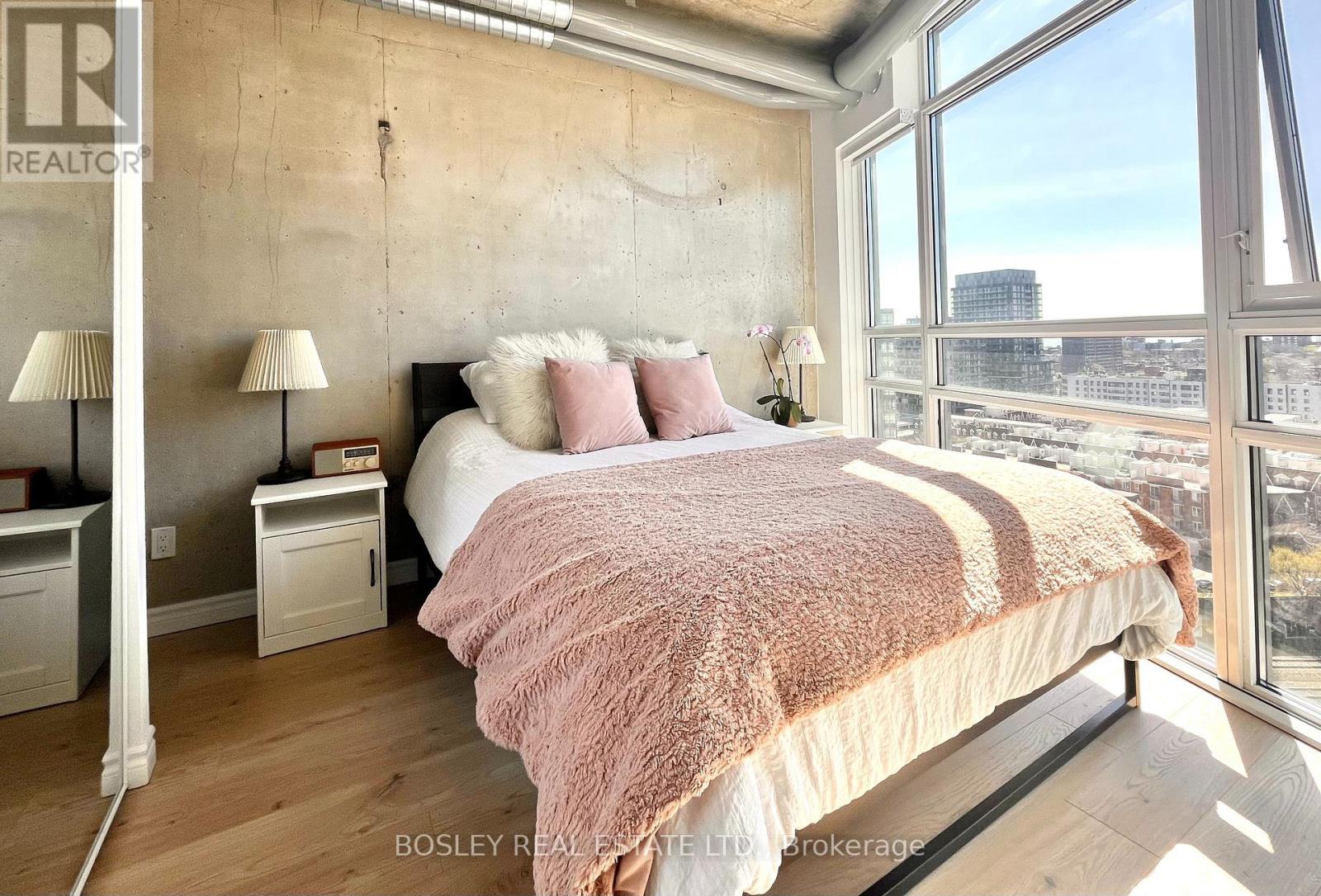 A bedroom with a large bed and a view of the city.