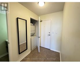 A bedroom with a white door and a mirror on the wall.