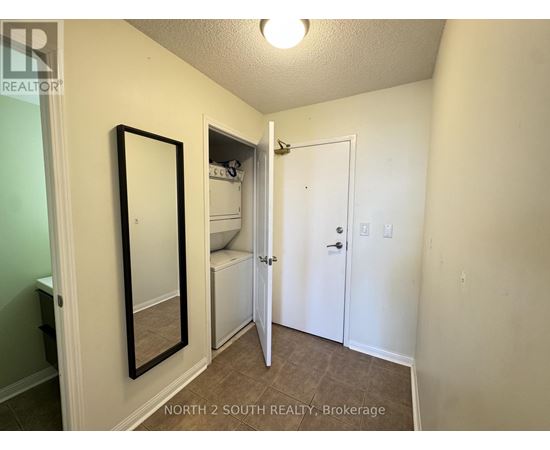 A bedroom with a white door and a mirror on the wall.