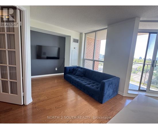 A living room with a blue couch and a flat screen TV.