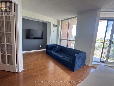A living room with a blue couch and a flat screen TV.