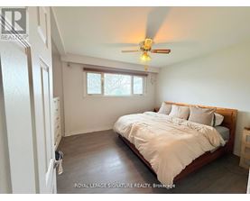 A bedroom with a bed, dresser, and window.