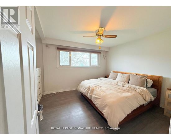 A bedroom with a bed, dresser, and window.