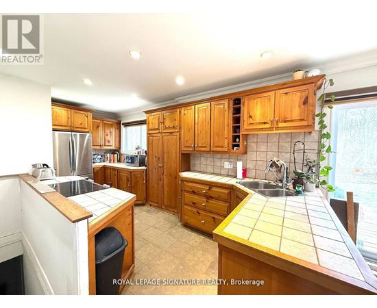 A kitchen with wooden cabinets and a tile backsplash.