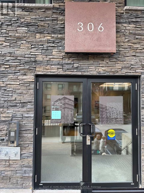 The door of a building with a glass window and a sign that says "306" above it.