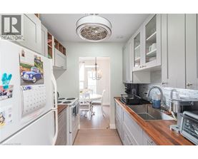 A kitchen with white cabinets and a white fridge.