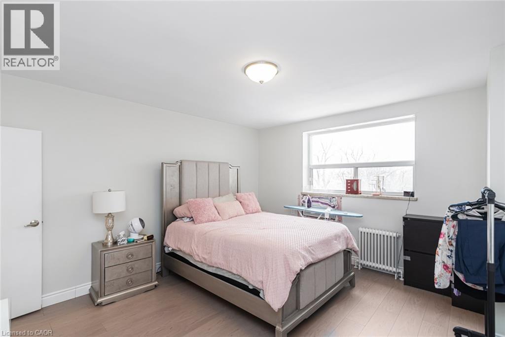 A bedroom with a bed, nightstand, and window.