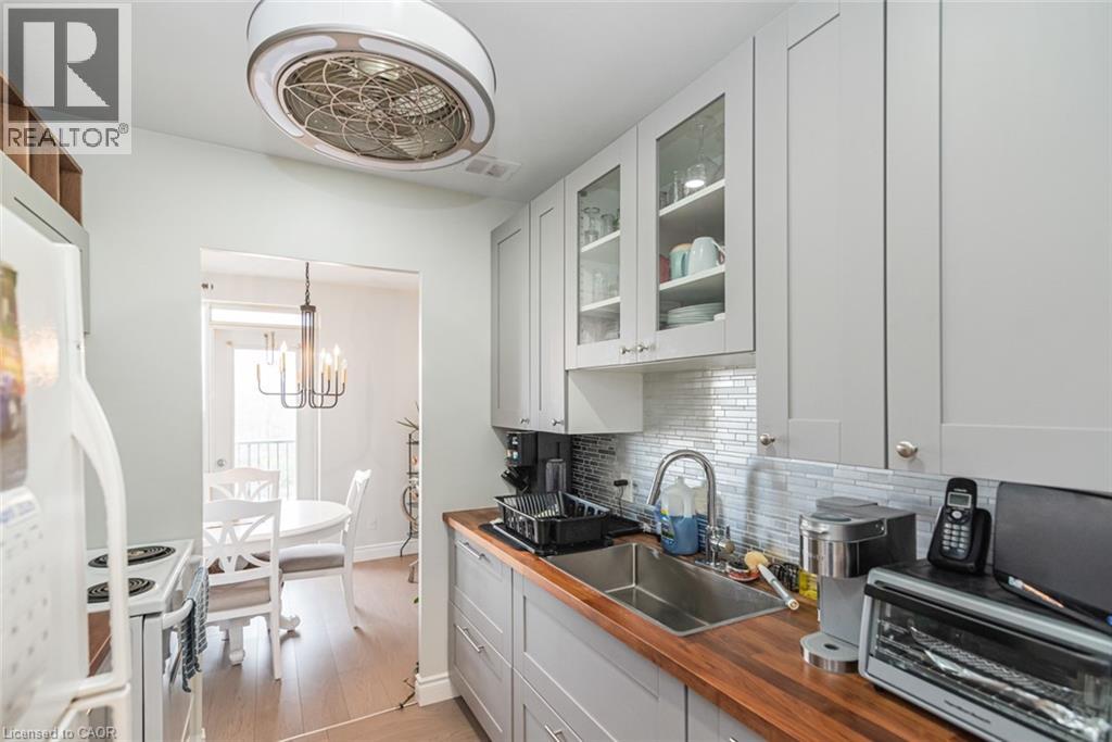 A well-lit kitchen with white cabinets and a wooden countertop.