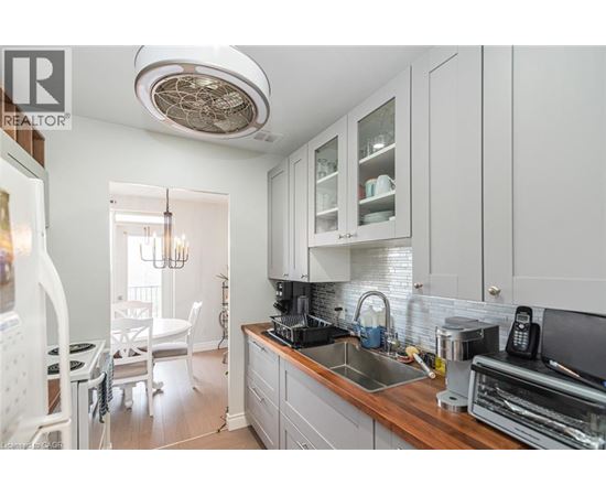 A well-lit kitchen with white cabinets and a wooden countertop.