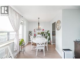 A dining room with a white table and chairs.