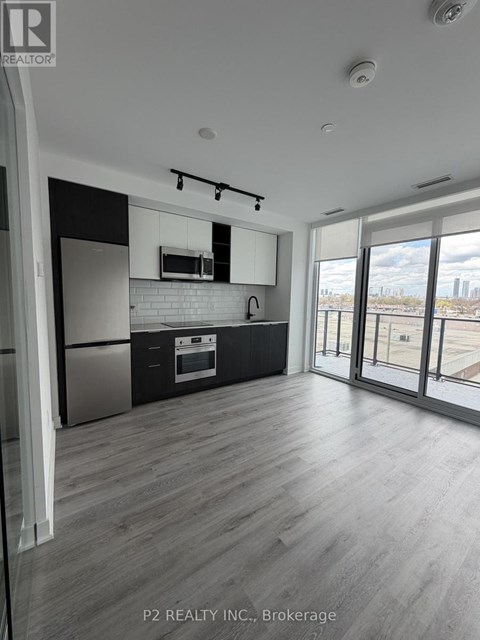 A modern kitchen with a stainless steel refrigerator and a white brick backsplash.