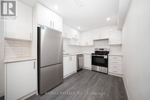 A modern kitchen with white cabinets and stainless steel appliances.