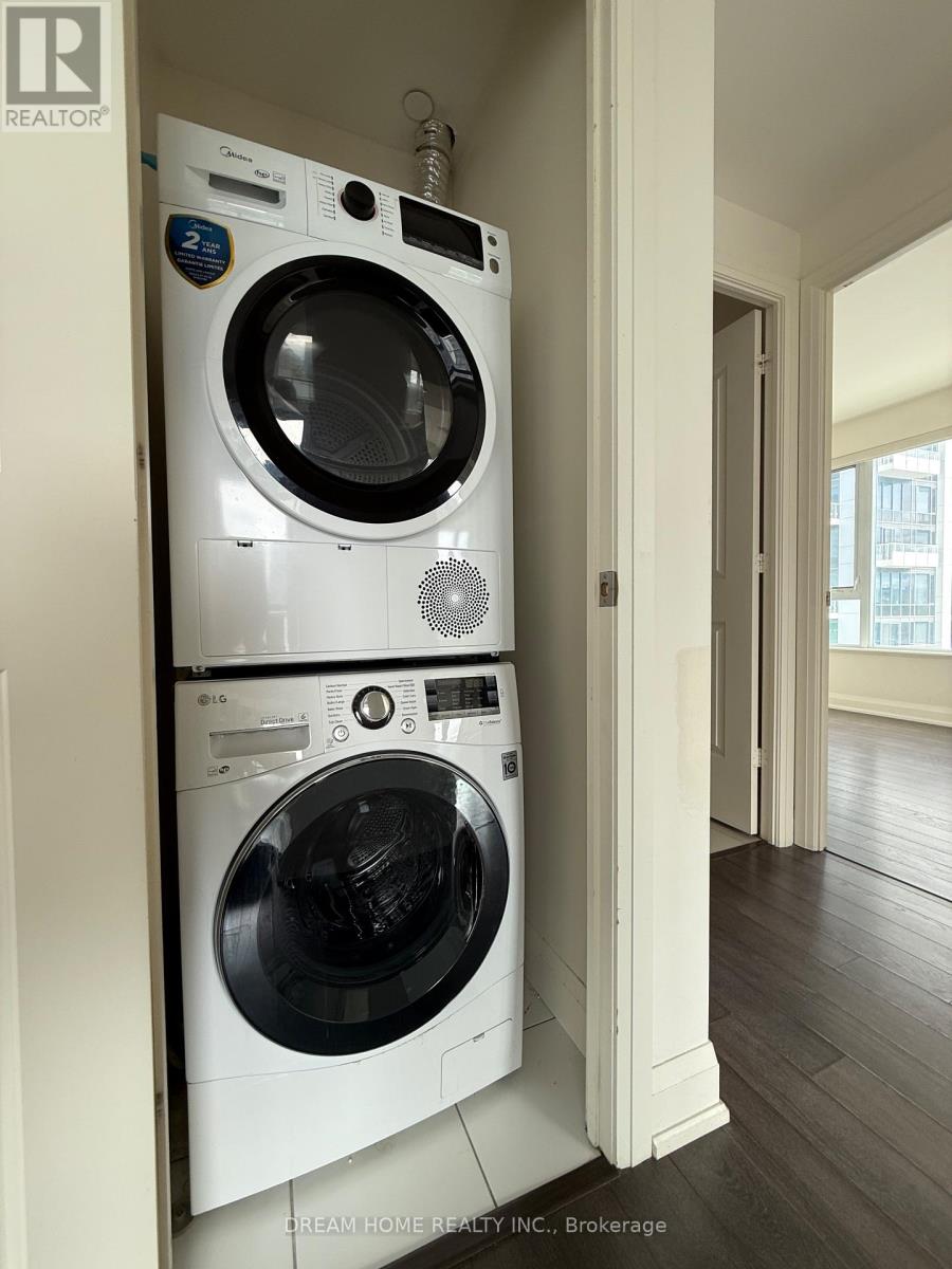 A white front loading washing machine is stacked on top of another white front loading washing machine.