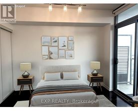 A bedroom with a bed, two lamps, and pictures on the wall.