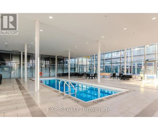 A large indoor swimming pool with a glass wall and a caption that reads "EXP REALTY, Brokerage".