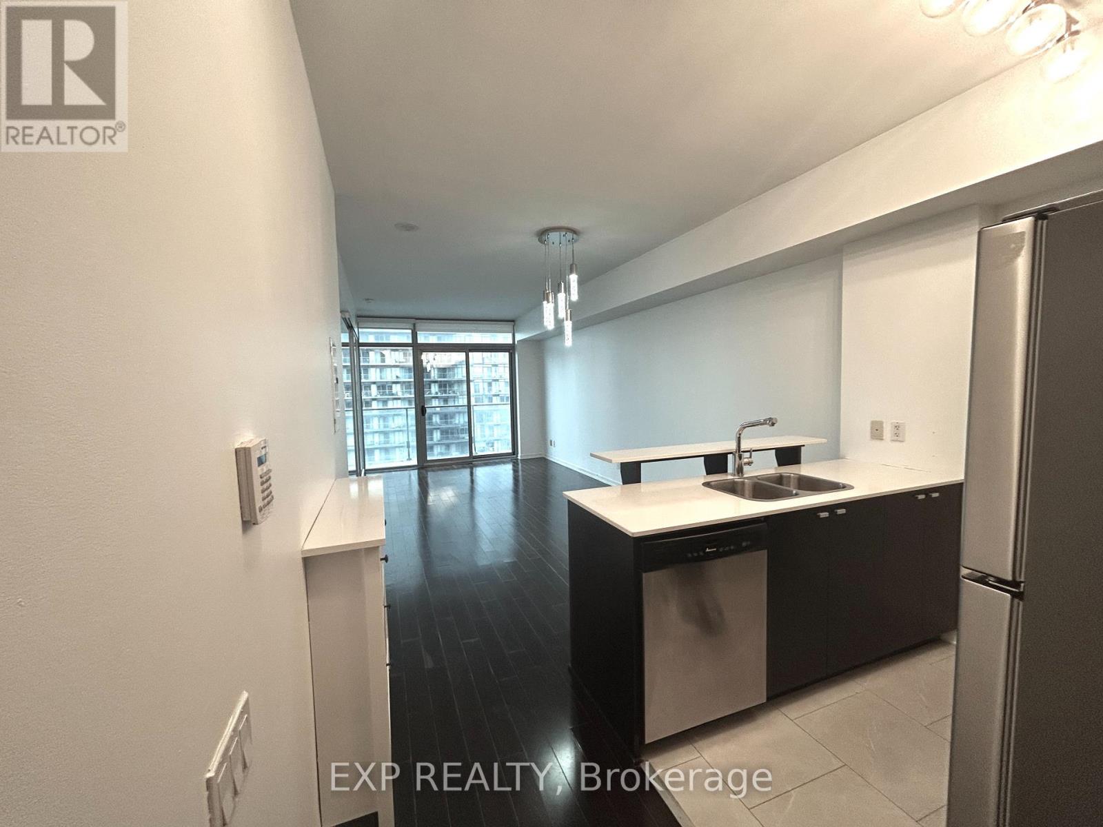 A kitchen with white cabinets and a black countertop.